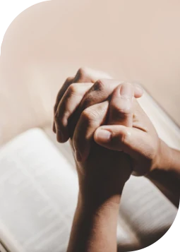 Woman with hands resting on an open Bible